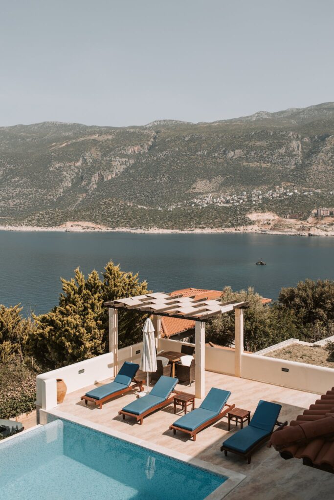 Aerial View Of Pool Lounge And Body Of Water Near Mountain